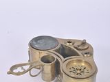 a small brass device that is sitting on a white surface