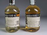 two bottles of alcohol sitting next to each other on a table