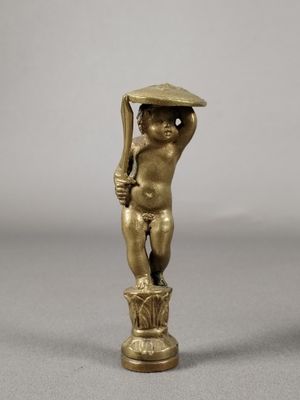 figurine en laiton représentant un garçon coiffé d'un chapeau et tenant un bâton
