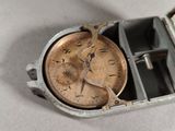 a small metal box with a watch inside of it