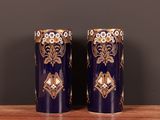 une paire de vases bleus et dorés posés sur une table en bois