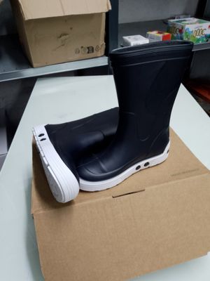 une paire de bottes de pluie noires posées sur une boîte