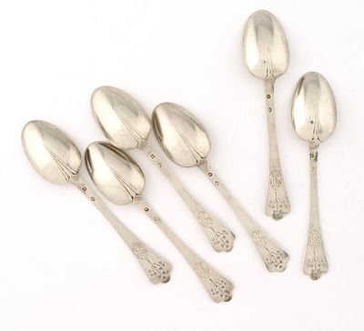 five silver spoons and a spoon with a spoon handle on a white surface