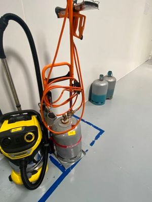 un aspirateur et un bac posés par terre dans une pièce