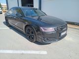 the black audi is parked in a parking lot next to a building