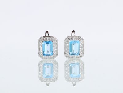 une photo d'une paire de boucles d'oreilles en topaze bleue et en topaze blanche