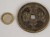 une petite pièce à côté d'une pièce encore plus petite, posées sur une surface blanche