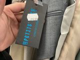 a person that is holding a tag in front of a rack of clothes