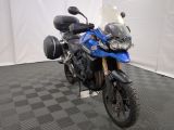 une moto bleue garée sur un sol à carreaux noirs et blancs