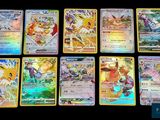Les cartes Pokémon sont alignées sur une surface noire.