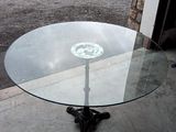 une table en verre ornée d'un motif représentant un crâne et des os croisés