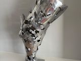 a metal sculpture on a white shelf in a room