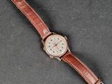 an image of a watch with a brown leather strap on a table