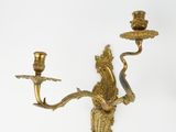 a gold colored candle holder with a bird on it