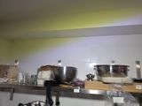 many bowls and pans sitting on a shelf in a kitchen