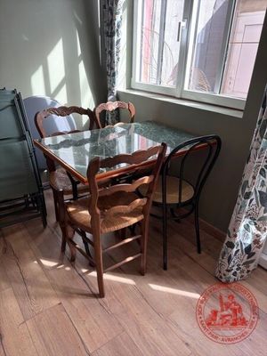 une table et des chaises en verre dans une pièce dotée d'une fenêtre