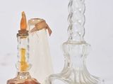 deux bougeoirs en verre et un porte-bougie posés sur une surface blanche