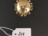 a close up of a gold brooch with a price tag on it
