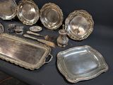 a lot of silver plates and spoons on a table