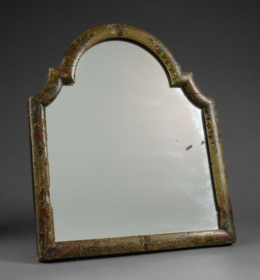 an old mirror with a decorative design on the top of it