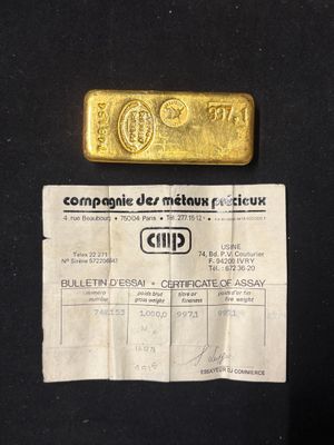 a gold bar and a certificate on a black table