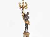 an image of a statue of a man holding a chandelier on a pedestal