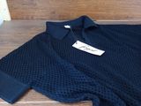navy blue knitted shirt with black collar and cuffs on a wooden bench