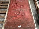 une grande table rouge sur laquelle est sculpté un homme