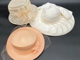 trois chapeaux et un voile posés sur une surface noire