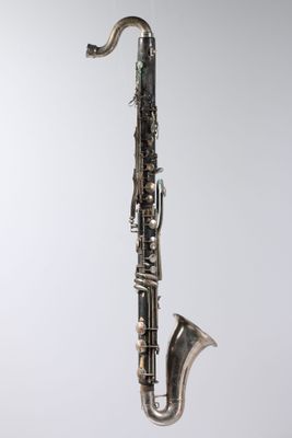 an old saxophone hanging from a string on a wall