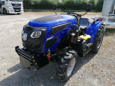 une photo d'un tracteur bleu garé sur un parking