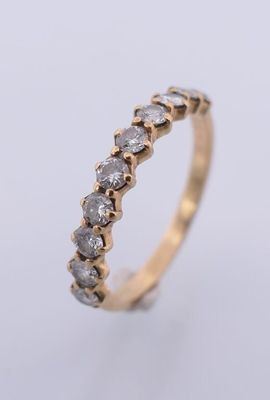 un gros plan d'une bague en or sertie d'une rangée de diamants
