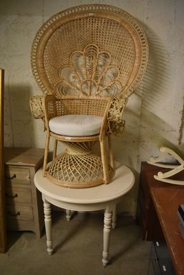 une chaise en osier posée sur une petite table dans une pièce