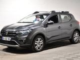 Le SUV gris est garé dans un garage dont le sol est en damier.