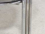 a glass table with two metal legs and a glass top
