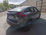 the rear end of a gray car parked in a parking lot