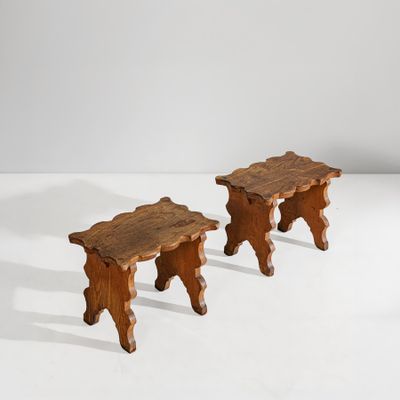 une paire de tabourets en bois posés sur une surface blanche