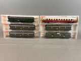 two model trains are sitting in plastic boxes on a table