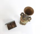 un petit vase et une petite boîte en bois posés sur une surface blanche