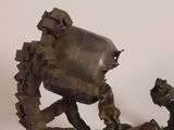 a bronze sculpture of a robot on a table