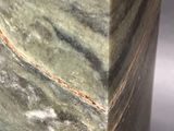 a close up of a green marble vase on a table