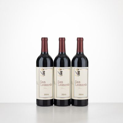 three bottles of red wine sitting on top of a table
