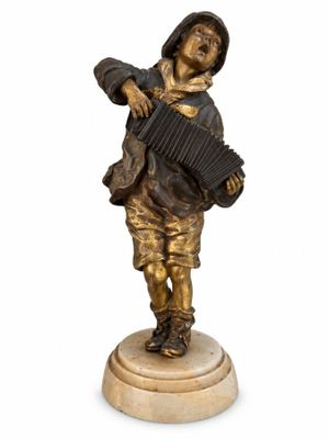 figurine en bronze représentant un garçon jouant de l'accordéon, posée sur un socle en marbre