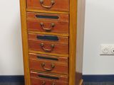 une petite commode en bois dans un coin de la pièce