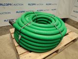 a green hose on a pallet in front of a wall
