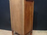 an image of a small wooden cabinet on a carpeted floor