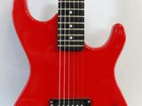 a red electric guitar sitting on top of a white surface