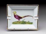 une petite assiette carrée sur laquelle est peint un oiseau