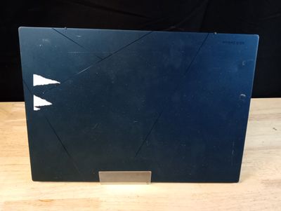 un ordinateur portable ouvert posé sur une table en bois