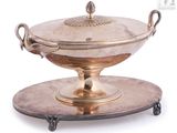 a silver plate with a bowl on it on a stand
